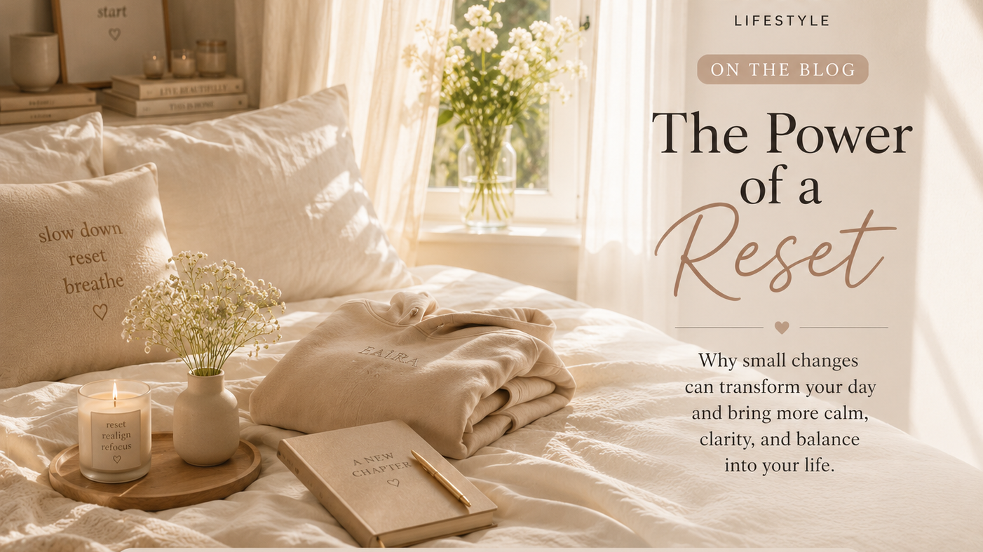 Sunlit minimalist bedroom with a cozy folded hoodie, journal, candle, and fresh flowers, representing intentional living, daily reset rituals, and a calm lifestyle
